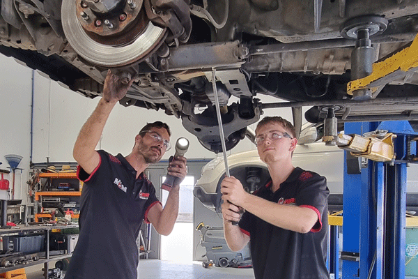 Phoenix and Daryn working underneath a car